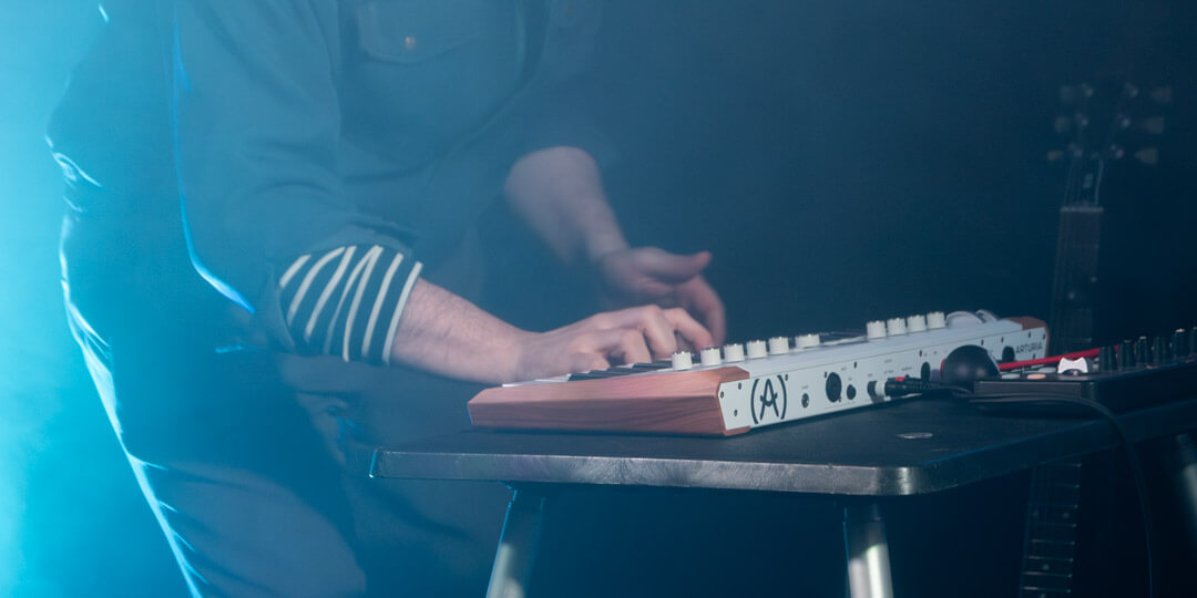hands playing on a keyboard at a concert